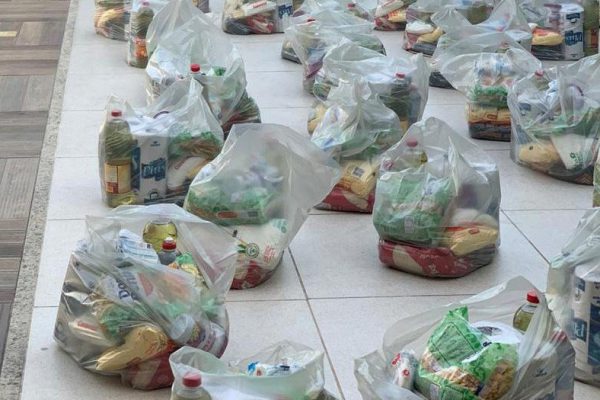 Voluntários montam cestas básicas para doações